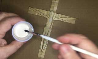 Use a paint brush to put a heavy coat of wood glue all over your crucifix.