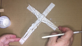 Photo of crucifix covered in glue.